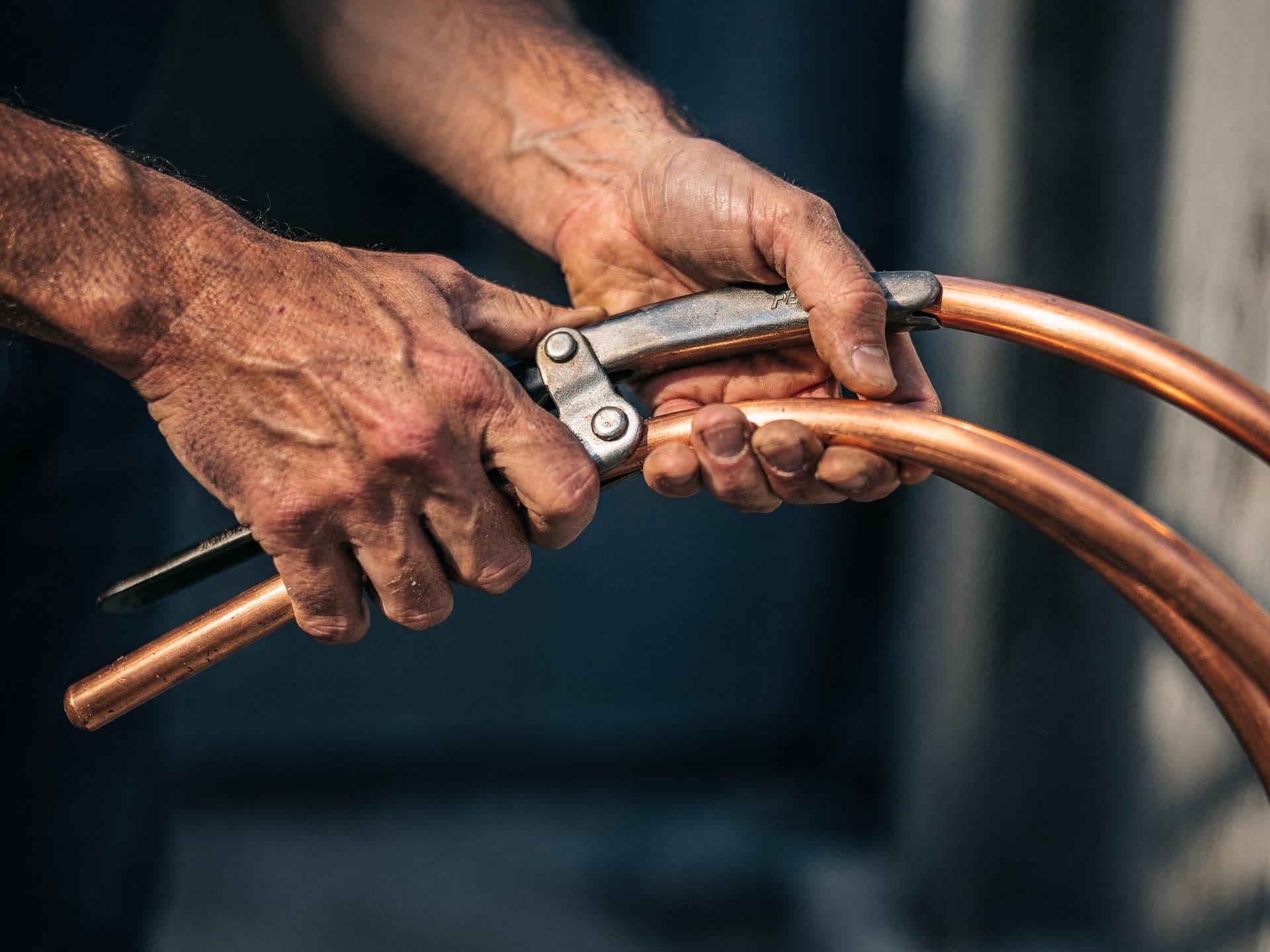 The owner bending a clean copper line-set on an install